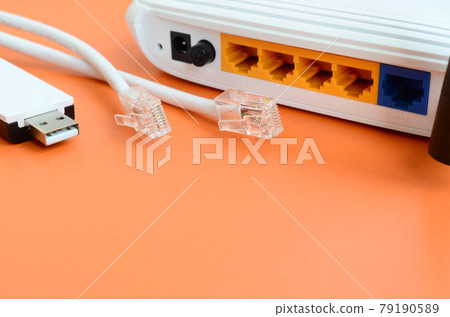 Internet router, portable USB wi-fi adapter and internet cable plugs lie on a bright orange background. Items required for internet connection Internet router, portable USB wi-fi adapter and internet cable plugs lie on a bright orange background. Items required for internet connection 79190589