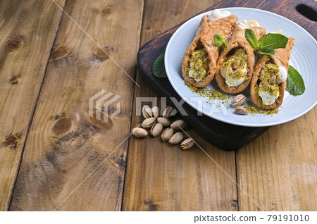 Cannoli Sicily. Traditional Italian sweet with ricotta and various fillings. Food on a wooden 79191010