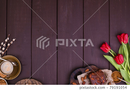 Fresh aromatic espresso and brownie, on a wooden table. Spring breakfast, flowers, tulips, pastries Fresh aromatic espresso and brownie, on a wooden table. Spring breakfast, flowers, tulips, pastries 79191054