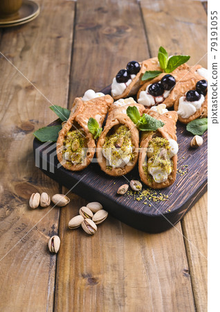 Cannoli Sicily. Traditional Italian sweet with ricotta and various fillings. Food on a wooden 79191055