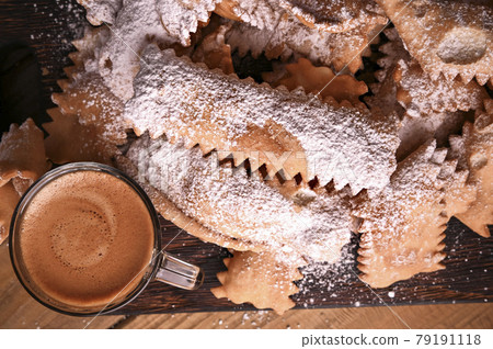 Carnival food TYPICAL and aromatic coffee on a woody background. Sfrappole or chiachiere or angel 79191118
