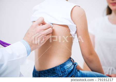 Pediatrician examining child with stethoscope 79191217