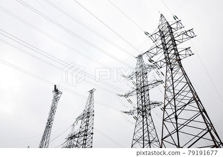 Towers power lines against a cloudy sky background. Electricity transmission pylons Towers power lines against a cloudy sky background. Electricity transmission pylons 79191677