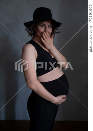 Pregnant caucasian woman touching her belly laughing covering mouth with hand. Pregnant caucasian woman touching her belly laughing covering mouth with hand. 79191906