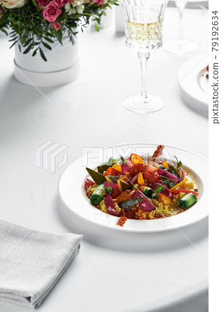 Stewed vegetables with coarsely chopped zucchini, carrots, eggplants and bell peppers, table with white tablecloth, copy space Stewed vegetables with coarsely chopped zucchini, carrots, eggplants and bell peppers, table with white tablecloth, copy space 79192634