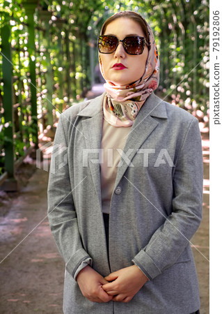 Portrait of beautiful stylish young muslim woman wearing grey suit and sunglasses Portrait of beautiful stylish young muslim woman wearing grey suit and sunglasses 79192806