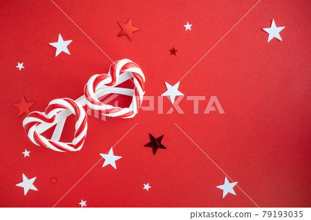 Carnival glasses with heart-shaped frames on a red background with space for text. Holiday banner layout. 79193035