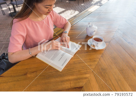 Asian woman reading book in the garden Asian woman reading book in the garden 79193572