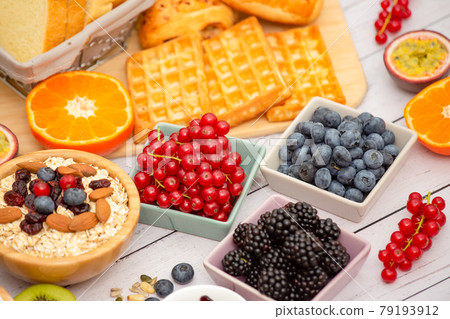Breakfast Served in the morning with Butter bread and corn flakes Whole grains and raisins with milk in cups and Strawberry, Blueberry, Raspberry, Kiwi, Fresh Orange on the breakfast table. Breakfast Served in the morning with Butter bread and corn flakes Whole grains and raisins with milk in cups and Strawberry, Blueberry, Raspberry, Kiwi, Fresh Orange on the breakfast table. 79193912