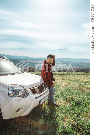 man standing near suv car at the top of the mountain 79194780