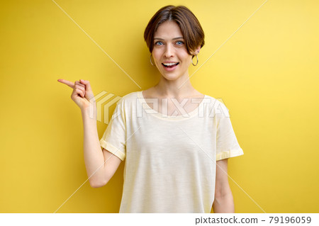 Pretty good-looking positive adult woman pointing finger at side copy space for advertisement 79196059