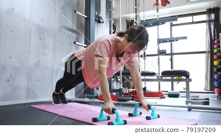 Woman doing push-ups in the gym Woman doing push-ups in the gym 79197209