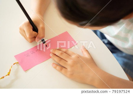 A child writing a wish on a strip of paper A child writing a wish on a strip of paper 79197524