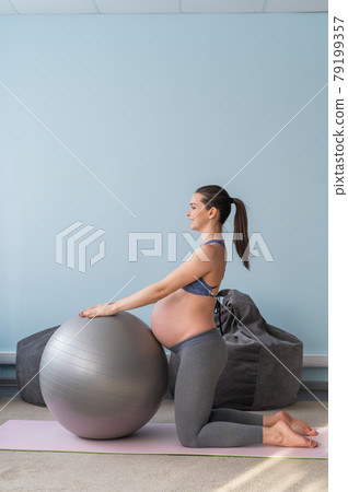 Pregnant caucasian woman on fitness with a ball. Yoga for expectant mothers. Girl in the classroom in preparation for childbirth. Pilates in the last trimester. Pregnant caucasian woman on fitness with a ball. Yoga for expectant mothers. Girl in the classroom in preparation for childbirth. Pilates in the last trimester. 79199357