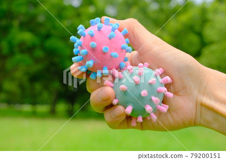 Hold the coronavirus model in your hand and imagine after-corona with the background as a forest 79200151