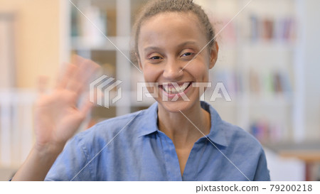 Portrait of Cheerful African Woman Waving at the Camera 79200218