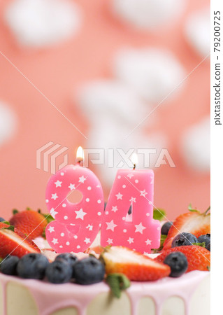 Birthday cake number 94. Beautiful pink candle in cake on pink background with white clouds. Close-up and vertical Birthday cake number 94. Beautiful pink candle in cake on pink background with white clouds. Close-up and vertical 79200725