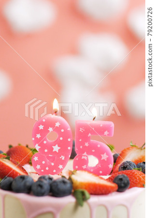 Birthday cake number 95. Beautiful pink candle in cake on pink background with white clouds. Close-up and vertical Birthday cake number 95. Beautiful pink candle in cake on pink background with white clouds. Close-up and vertical 79200726