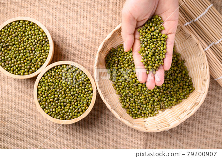 Mung bean seeds in hand and pouring into bamboo basket Mung bean seeds in hand and pouring into bamboo basket 79200907