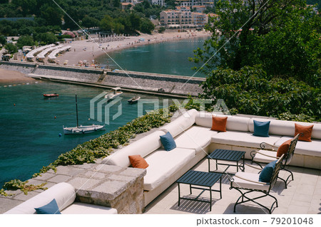 Sea view restaurant - cozy sofas with pillows and wrought iron chairs, near the water. Sea view restaurant - cozy sofas with pillows and wrought iron chairs, near the water. 79201048
