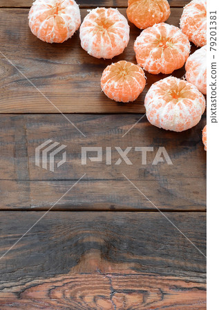 A lot of fresh orange mandarins lie on a brown wooden background A lot of fresh orange mandarins lie on a brown wooden background 79201381