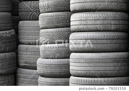 Old used tires stacked with high piles in secondary car parts shop garage 79201558