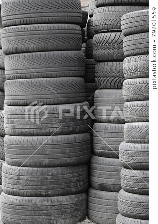 Old used tires stacked with high piles in secondary car parts shop garage 79201559