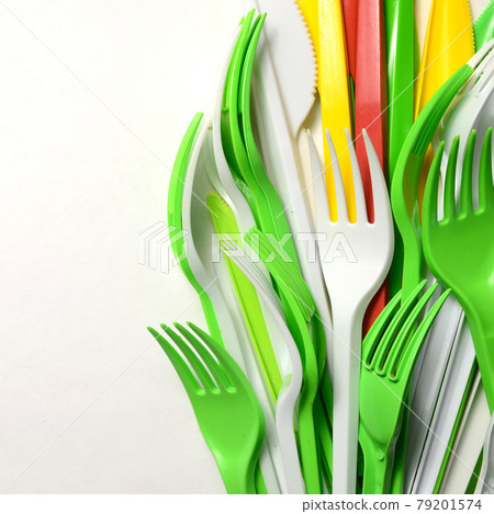 Pile of bright yellow, green and white plastic kitchenware single use appliances Pile of bright yellow, green and white plastic kitchenware single use appliances 79201574