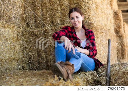 Female farmer posing on hayloft at cow farm Female farmer posing on hayloft at cow farm 79201973