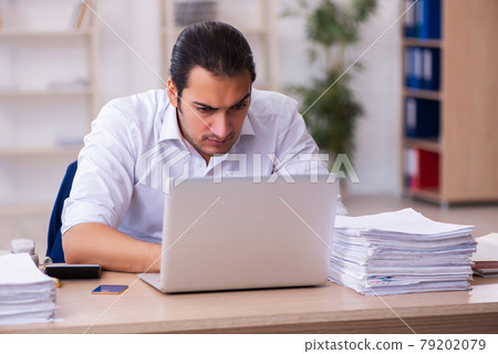 Young businessman employee unhappy with excessive work in the office Young businessman employee unhappy with excessive work in the office 79202079