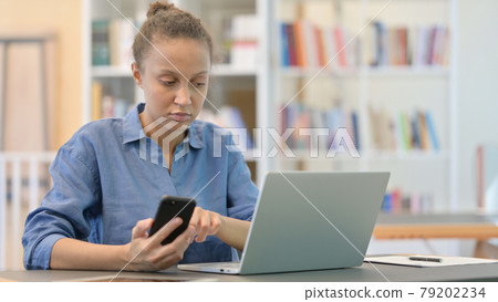 African Woman using Smartphone and Laptop in Library African Woman using Smartphone and Laptop in Library 79202234