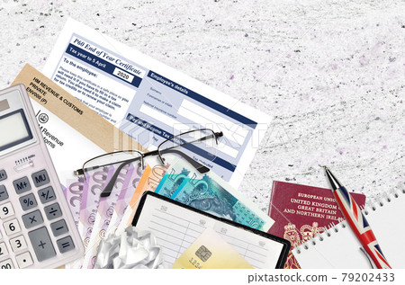 English Tax form P60 End of year certificate by HM revenue and customs lies on table with office items. HMRC paperwork and tax paying process in United Kingdom English Tax form P60 End of year certificate by HM revenue and customs lies on table with office items. HMRC paperwork and tax paying process in United Kingdom 79202433