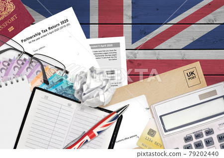 English Tax form sa800 Partnership tax return 2020 from HM revenue and customs lies on table with office items. HMRC paperwork and tax paying process in United Kingdom 79202440
