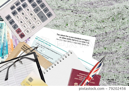 English form sa700 Tax return for a non-resident company or other entity liable to income tax from HM revenue and customs lies on table with office items. HMRC paperwork English form sa700 Tax return for a non-resident company or other entity liable to income tax from HM revenue and customs lies on table with office items. HMRC paperwork 79202456