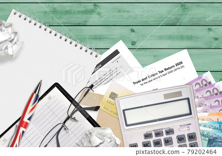 English Tax form sa900 Trust and estate tax return 2020 from HM revenue and customs lies on table with office items. HMRC paperwork and tax paying process in United Kingdom English Tax form sa900 Trust and estate tax return 2020 from HM revenue and customs lies on table with office items. HMRC paperwork and tax paying process in United Kingdom 79202464