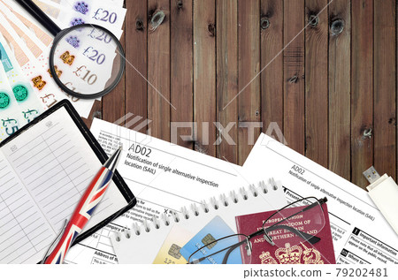 English form AD02 Notification of single alternative inspection location SAIL from Companies House service lies on table with office items. CH business and paperwork process 79202481
