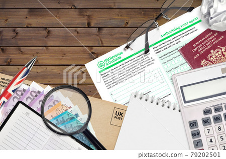 English form 64-8 Authorising your agent from HM revenue and customs lies on table with office items. HMRC paperwork and tax paying process in United Kingdom English form 64-8 Authorising your agent from HM revenue and customs lies on table with office items. HMRC paperwork and tax paying process in United Kingdom 79202501