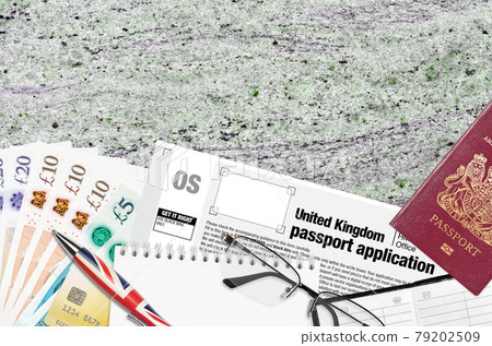 English form OS United Kingdom passport application from HM passport office lies on table with office items. UK passport paperwork English form OS United Kingdom passport application from HM passport office lies on table with office items. UK passport paperwork 79202509