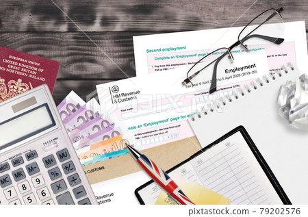 English Tax form sa102 Employment by HM revenue and customs lies on table with office items. HMRC paperwork and tax paying process in United Kingdom English Tax form sa102 Employment by HM revenue and customs lies on table with office items. HMRC paperwork and tax paying process in United Kingdom 79202576