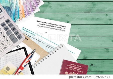 English form sa700 Tax return for a non-resident company or other entity liable to income tax from HM revenue and customs lies on table with office items. HMRC paperwork English form sa700 Tax return for a non-resident company or other entity liable to income tax from HM revenue and customs lies on table with office items. HMRC paperwork 79202577