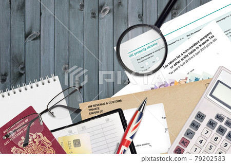 English form sa700 Tax return for a non-resident company or other entity liable to income tax from HM revenue and customs lies on table with office items. HMRC paperwork English form sa700 Tax return for a non-resident company or other entity liable to income tax from HM revenue and customs lies on table with office items. HMRC paperwork 79202583