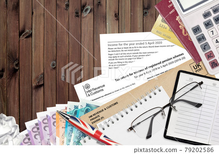 English Tax form sa970 Tax return for trustees of registered pension schemes from HM revenue and customs lies on table with office items. HMRC paperwork and tax paying process English Tax form sa970 Tax return for trustees of registered pension schemes from HM revenue and customs lies on table with office items. HMRC paperwork and tax paying process 79202586