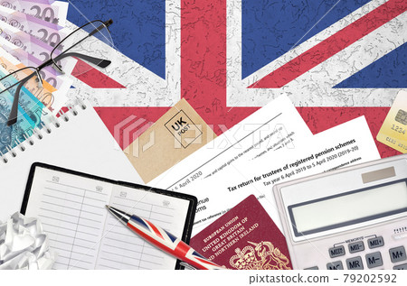 English Tax form sa970 Tax return for trustees of registered pension schemes from HM revenue and customs lies on table with office items. HMRC paperwork and tax paying process 79202592