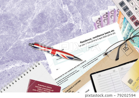English Tax form sa108 Residence remittance basis etc from HM revenue and customs lies on table with office items. HMRC paperwork and tax paying process in United Kingdom English Tax form sa108 Residence remittance basis etc from HM revenue and customs lies on table with office items. HMRC paperwork and tax paying process in United Kingdom 79202594