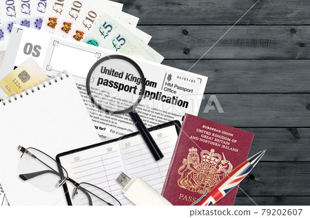 English form OS United Kingdom passport application from HM passport office lies on table with office items. UK passport paperwork English form OS United Kingdom passport application from HM passport office lies on table with office items. UK passport paperwork 79202607