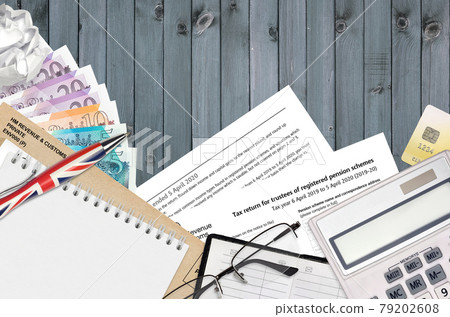 English Tax form sa970 Tax return for trustees of registered pension schemes from HM revenue and customs lies on table with office items. HMRC paperwork and tax paying process English Tax form sa970 Tax return for trustees of registered pension schemes from HM revenue and customs lies on table with office items. HMRC paperwork and tax paying process 79202608