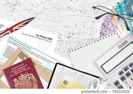 English form sa100 Tax return by HM revenue and customs lies on table with office items. HMRC paperwork and tax paying process in United Kingdom English form sa100 Tax return by HM revenue and customs lies on table with office items. HMRC paperwork and tax paying process in United Kingdom 79202620