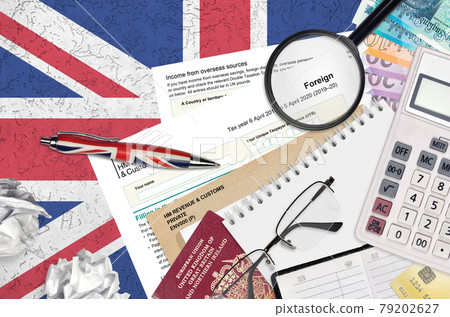 English Tax form sa106 Foreign from HM revenue and customs lies on table with office items. HMRC paperwork and tax paying process in United Kingdom English Tax form sa106 Foreign from HM revenue and customs lies on table with office items. HMRC paperwork and tax paying process in United Kingdom 79202627