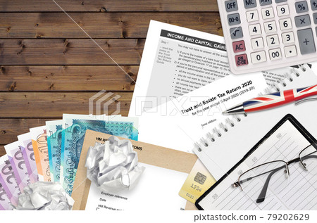English Tax form sa900 Trust and estate tax return 2020 from HM revenue and customs lies on table with office items. HMRC paperwork and tax paying process in United Kingdom English Tax form sa900 Trust and estate tax return 2020 from HM revenue and customs lies on table with office items. HMRC paperwork and tax paying process in United Kingdom 79202629