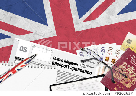 English form OS United Kingdom passport application from HM passport office lies on table with office items. UK passport paperwork English form OS United Kingdom passport application from HM passport office lies on table with office items. UK passport paperwork 79202637